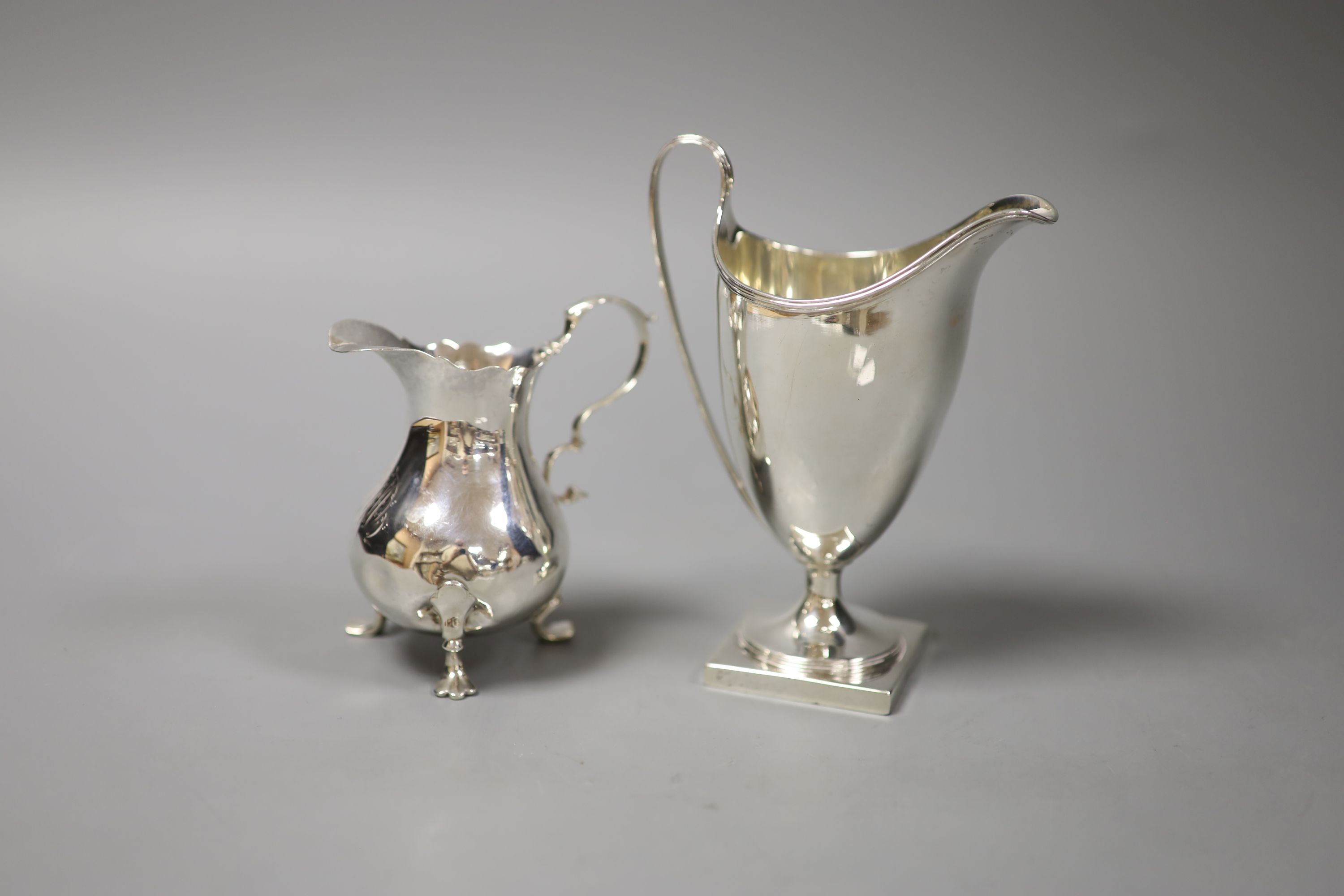 A George III silver helmet cream jug, London 1791 and another cream jug of bellied form,